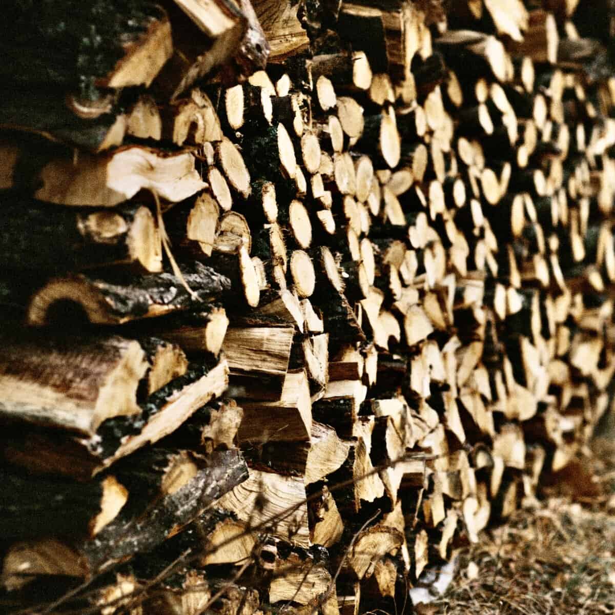 Ein Stapel Brennholzscheite, ordentlich im Freien aufgestapelt.