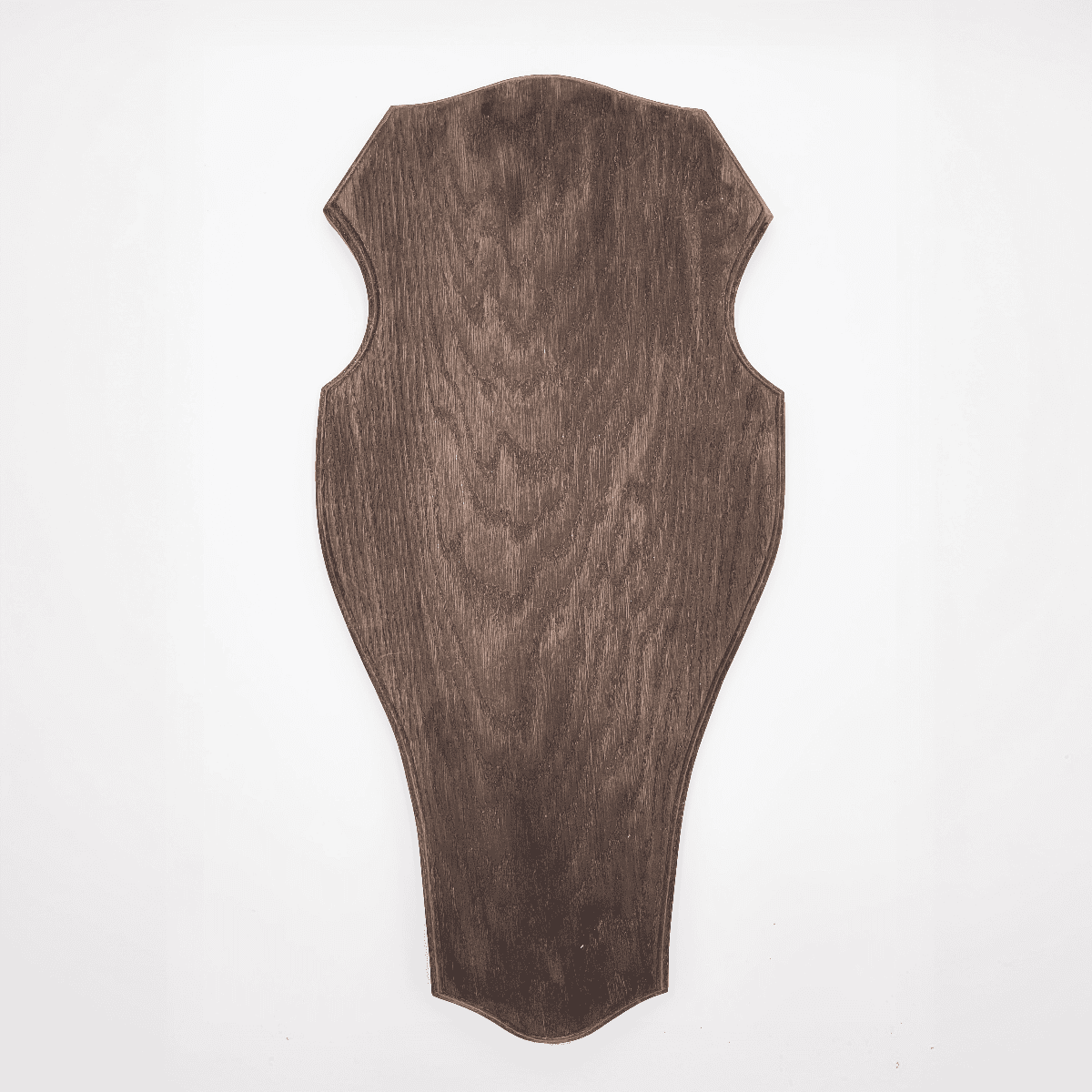 Trophäenschild Hirsch, eine dunkle Holztafel in verzierter schildähnlicher Form auf weißem Hintergrund.