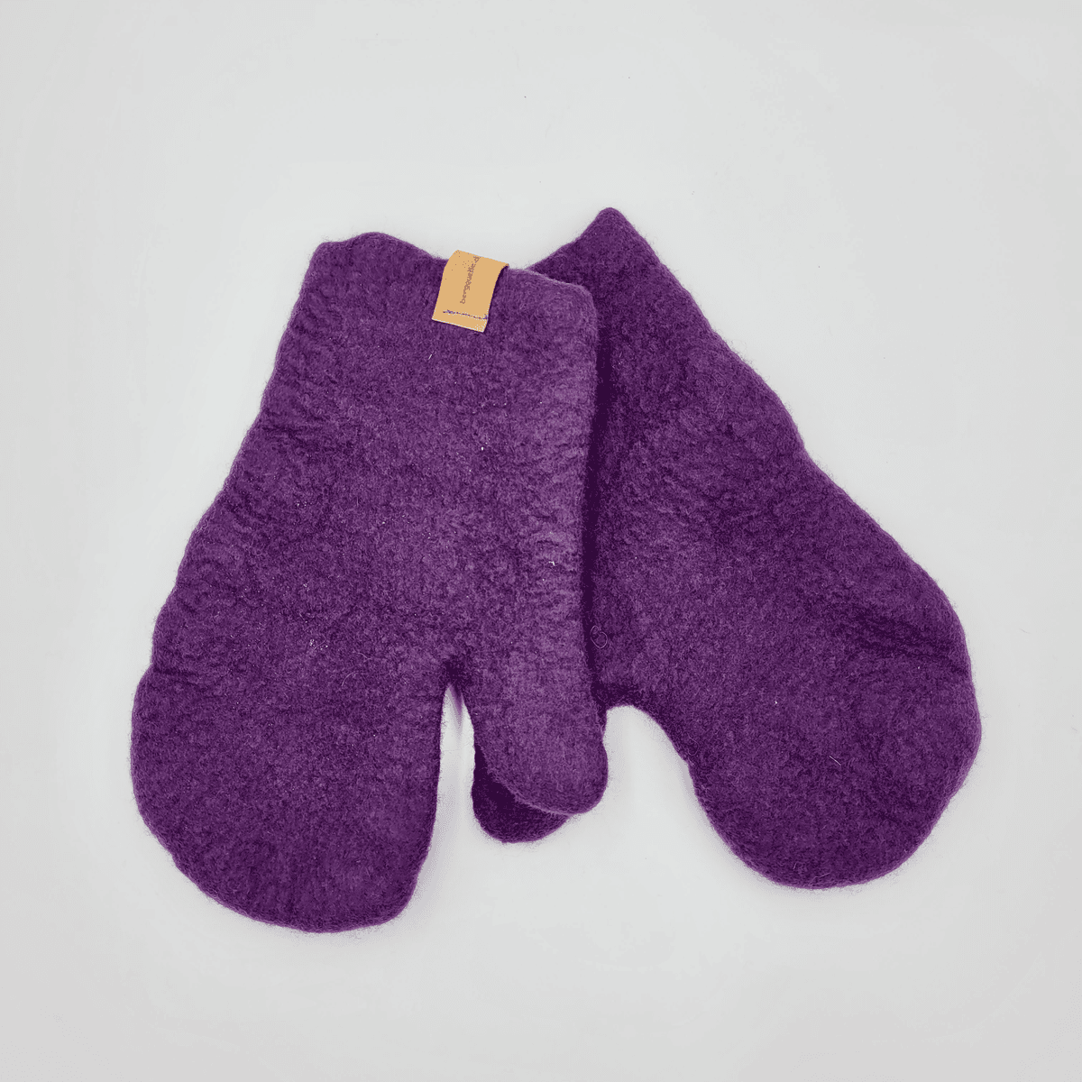 Ein Paar lila Filzfäustlinge von Backofenhandschuhe mit einem kleinen Etikett auf einem Fäustling.