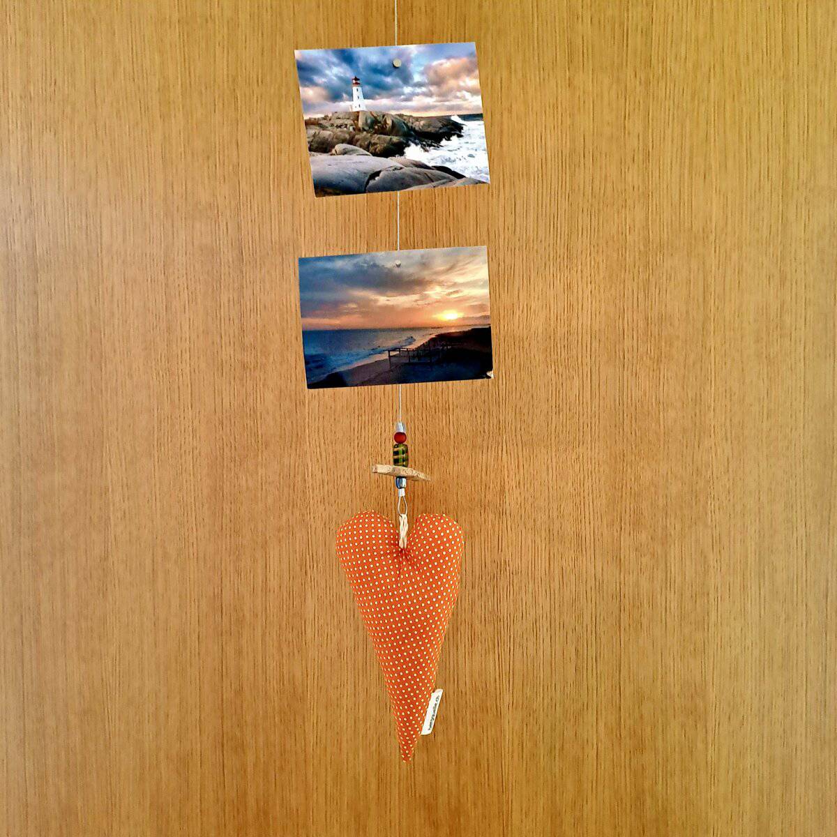 Die „Fotoleine mit Herz“ zeigt zwei Leuchtturmfotos und ein gepunktetes Herz, das an einer Holztür hängt.