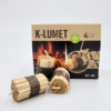 Drei K-LUMET Feueranzünder werden vor ihrer Verpackung präsentiert, verziert mit Bildern von Brennholz und Flammen.