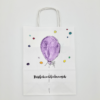 Papiertasche bemalt mit einem weißen Geschenktüten-Design mit einem lila Luftballon, bunten Punkten und dem Text „Herzlichen Glückwunsch“.