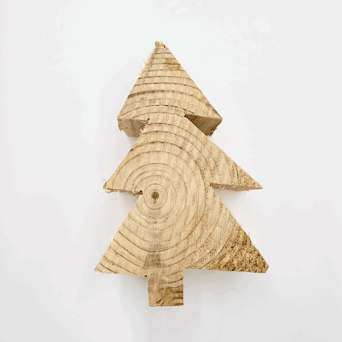 Der hölzerne Weihnachtsbaumaufsteller von Tanne weist sichtbare Jahresringe auf einem weißen Hintergrund auf.